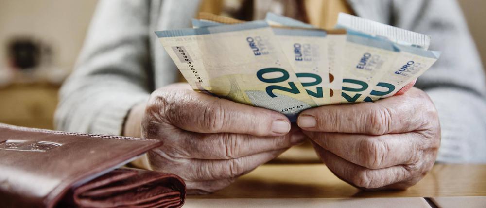 Eine Seniorin zählt ihr Geld.