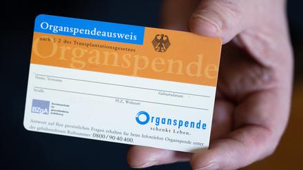 Eine Frau hält einen Organspendeausweis in ihren Händen.