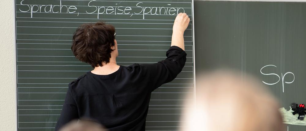 ARCHIV - 13.05.2019, Baden-Württemberg, Remshalden: Eine Lehrerin schreibt in einer Schule Worte an eine Tafel.
Weil Zehntausende von Lehrkräften fehlen und Baden-Württemberg in den Bildungsstudien ordentlich Federn gelassen hat, fordert der Lehrerverband VBE Kompromisse in der Ausbildung der Pädagogen. (zu dpa «Lehrerverband fordert Konzept für Quereinsteiger an Schulen») Foto: Sebastian Gollnow/dpa +++ dpa-Bildfunk +++