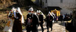 Verwandte und Nachbarn einer Verstorbenen bei deren Beerdigung Anfang Januar in einem Dorf im Kreis Tonglu, Provinz Zhejiang.