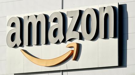 ARCHIV - 17.01.2019, Niedersachsen, Garbsen: Logo und Schriftzug von Amazon an einem Paketzentrum des Online-Händlers. Das US-Unternehmen Amazon überträgt ab der Saison 2021/22 Spiele der Fußball-Champions-League. (zu dpa: «Champions League ab 2021 auch bei Amazon») Foto: Holger Hollemann/dpa +++ dpa-Bildfunk +++ | Verwendung weltweit