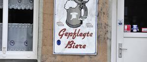 Eine Kneipe in Kreuzberg wirbt mit gepflegten Bieren. In den Gardinen und auf einem Schild befinden sich zahlreiche Hertha BSC-Logos und Aufkleber. Gepflegtes Bier *** A pub in Kreuzberg advertises with cultivated beers In the curtains and on a sign there are numerous Hertha BSC logos and stickers cultivated beer  