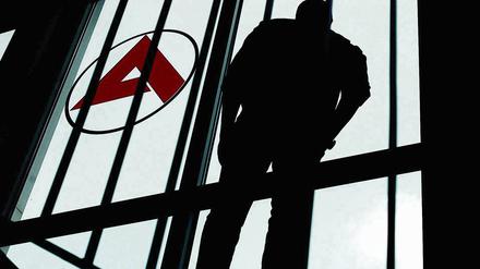 Ein Mann steht in Gladbeck im Flur der Arbeitsagentur und schaut aus dem Fenster.