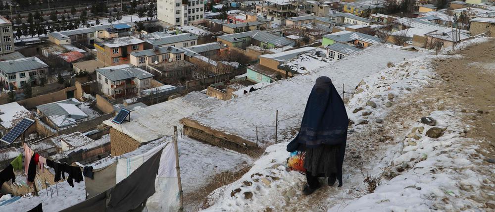 Eine Frau geht an einem kalten Wintertag in Fayzabad in der Provinz Badakhshan am 18. Januar 2023 einen Weg entlang.