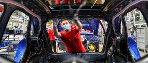 Ein Mitarbeiter von Porsche arbeitet mit Mundschutz.