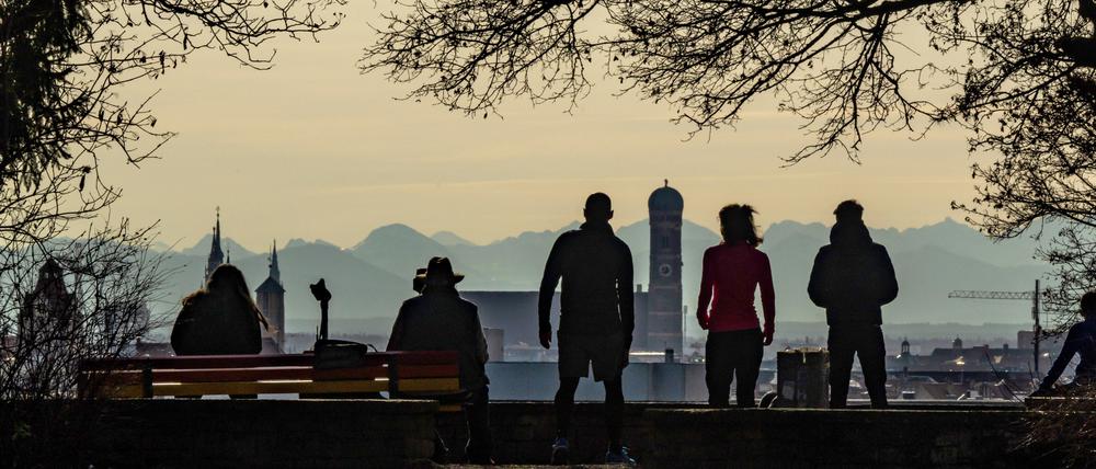 02.01.2023, Bayern, München: Spaziergänger und Freizeitsportler genießen bei Föhnwetter auf dem Luitpoldhügel im Stadtteil Schwabing den Ausblick auf die Kulisse der bayerischen Landeshauptstadt. Im Hintergrund ist das Alpenpanorama zu erkennen, wobei die Entfernung zwischen der Innenstadt und den Alpen etwa 100 Kilometer beträgt. Foto: Peter Kneffel/dpa +++ dpa-Bildfunk +++