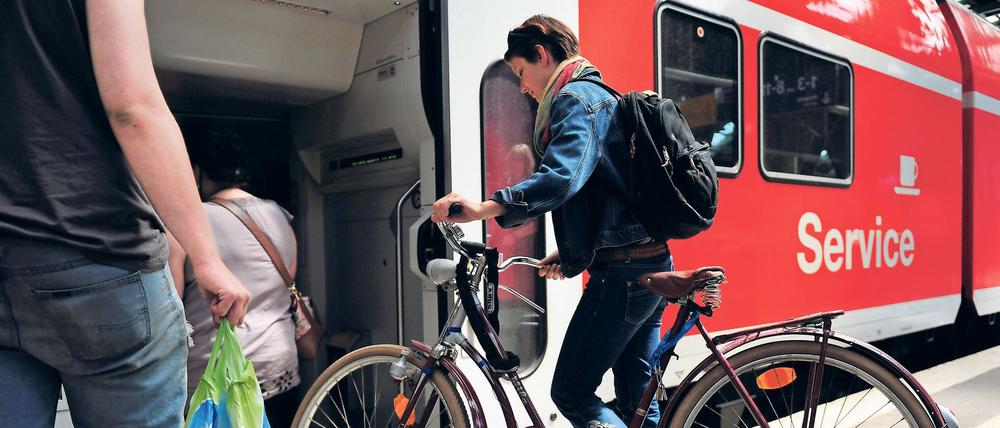 Eine junge Frau besteigt am Freitag (10.06.2011) auf dem Ostbahnhof in Berlin einen Zug mit ihrem Fahrrad. Der Radtransport per Bahn wird zu Spitzenzeiten wie an Pfingsten manchmal zum Risiko. Die Radler kämpfen nach Angaben des Fahrgastverbandes Pro Bahn häufig um die knappen Plätze im Regionalzug. Foto: Hannibal dpa/lbn +++(c) dpa - Bildfunk+++