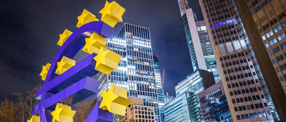 Die große Skulptur des Euro-Symbols steht am frühen Morgen vor den Hochhäusern des Frankfurter Bankenviertels.