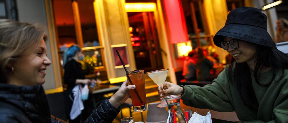 Zwei junge Frauen vor einer Cocktailbar in Berlin.