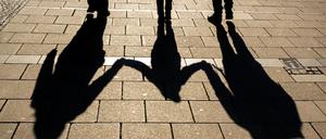 ARCHIV - 04.04.2022, Bayern, München: Die Schatten von zwei Erwachsenen und einem Kind fallen in den Morgenstunden auf den Asphalt.Die Einführung einer sogenannten Kindergrundsicherung gehört zu den zentralen sozialpolitischen Vorhaben der Ampelkoalition. Nun hat Bundesfamilienministerin Paus (Grüne) dafür Eckpunkte vorgelegt. Ein Ministeriumssprecher bestätigte am Donnerstag, dass ein entsprechendes Papier an die anderen Ministerien zur weiteren Abstimmung verschickt wurde. Foto: Peter Kneffel/dpa +++ dpa-Bildfunk +++
