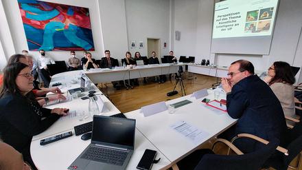 Staatssekretär Tobias Dünow informiert sich im Gespräch mit  Professorinnen und Professoren sowie Studierenden über den Einsatz von Künstlicher Intelligenz (KI) in der Forschung und Lehre an der Universität Potsdam.