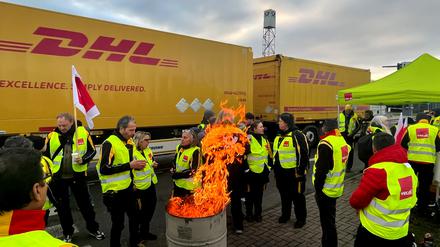 In Köln stehen streikende Mitarbeitende der Post vor einem LKW.