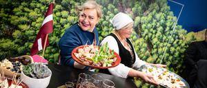 Zwei Frauen präsentieren auf dem Stand von Lettland Speisen bei der Grüne Woche im Januar. 