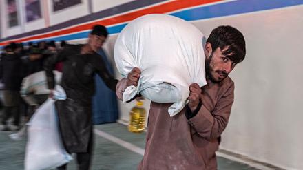 Ein Mann in Kabul schleppt einen Sack mit Lebensmitteln von einer Hilfsorganisation in Kabul. 