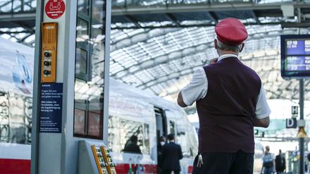  Ein Zugbegleiter gibt ein Abfahrtszeichen für einen ICE auf dem Bahnsteig im Berliner Hauptbahnhof. 