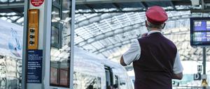  Ein Zugbegleiter gibt ein Abfahrtszeichen für einen ICE auf dem Bahnsteig im Berliner Hauptbahnhof. 