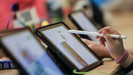 Tablets stehen in einer Reihe auf einem Tisch.