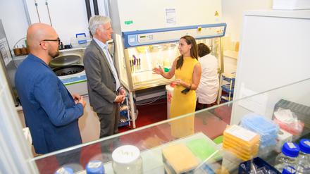 Besuch am Campus Buch. Wirtschaftssenator Stephan Schwarz und Staatssekretär MIchael Biel (blauer Anzug) im Gespräch mit Elisa Kieback, Gründerin und Chief Technology Officer des Biotech-Startups T-Knife, ein Spin-off vom Max-Delbrück-Centrum und Charité.
