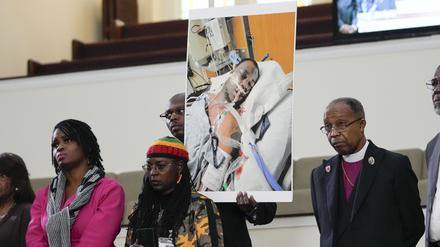 23.01.2023, USA, Memphis: Familienmitglieder und Unterstützer halten ein Foto von Tyre Nichols, der starb, nachdem er von Polizeibeamten aus Memphis verprügelt wurde, während einer Pressekonferenz mit dem Bürgerrechtsanwalt Ben Crump in Memphis, Tennessee. Der 29-jährige Tyre Nichols sei mehrere Minuten lang von den Einsatzkräften zusammengeschlagen worden, sagte einer der Anwälte der Familie. Foto: Gerald Herbert/AP/dpa - ACHTUNG: Nur zur redaktionellen Verwendung und nur mit vollständiger Nennung des vorstehenden Credits +++ dpa-Bildfunk +++