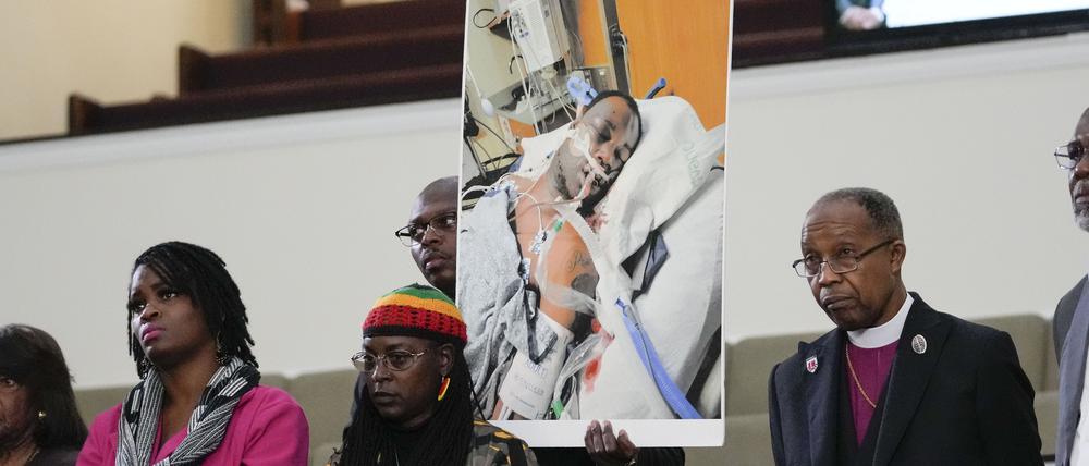 23.01.2023, USA, Memphis: Familienmitglieder und Unterstützer halten ein Foto von Tyre Nichols, der starb, nachdem er von Polizeibeamten aus Memphis verprügelt wurde, während einer Pressekonferenz mit dem Bürgerrechtsanwalt Ben Crump in Memphis, Tennessee. Der 29-jährige Tyre Nichols sei mehrere Minuten lang von den Einsatzkräften zusammengeschlagen worden, sagte einer der Anwälte der Familie. Foto: Gerald Herbert/AP/dpa - ACHTUNG: Nur zur redaktionellen Verwendung und nur mit vollständiger Nennung des vorstehenden Credits +++ dpa-Bildfunk +++