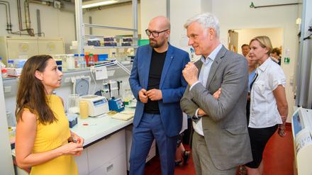 Besuch am Campus Buch. Wirtschaftssenator Stephan Schwarz und Staatssekretär Michael Biel (blauer Anzug) im Gespräch mit einer Gründerin. 