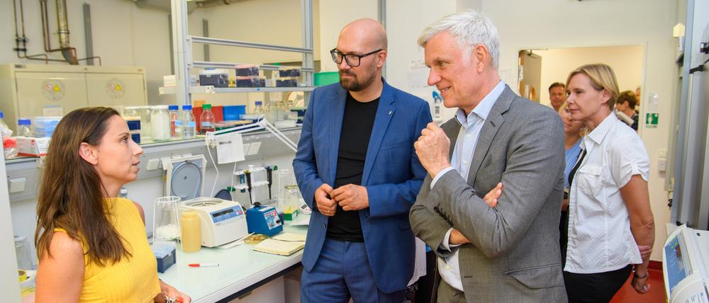 Besuch am Campus Buch. Wirtschaftssenator Stephan Schwarz und Staatssekretär Michael Biel (blauer Anzug) im Gespräch mit einer Gründerin. 
