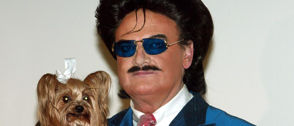 Der Modezar Rudolph Moshammer hält sein Hündchen „Daisy“ bei einer Pressekonferenz. Der wegen des Mordes an Moshammer verurteilte Iraker wird in sein Herkunftsland abgeschoben.