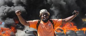 Ein Demonstrant vor einer brennenden Barrikade in Port-au-Prince.