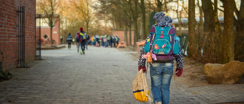 Ein Schulkind der Grundschule Russee in Kiel geht über den Schulhof zum Unterricht. Trotz weiterhin verschärfter Kontaktbeschränkungen für die Bevölkerung in der Coronakrise sollen in Schleswig-Holstein ab heute Grundschüler und Kindergartenkinder wie die jeweiligen Einrichtungen besuchen.
