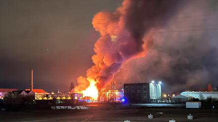 28.01.2023, Berlin: Flammen schlagen hoch in den Nachthimmel über Berlin. Ein Feuer in einer Lagerhalle im Berliner Ortsteil Oberschöneweide hat am frühen Samstagmorgen ein Großaufgebot von über 100 Einsatzkräften auf den Plan gerufen. Beim Eintreffen der Feuerwehr stellte sich heraus, dass die Lagerhalle eines Parkettherstellers in voller Ausdehnung brannte. Foto: Julius-Christian Schreiner/dpa +++ dpa-Bildfunk +++