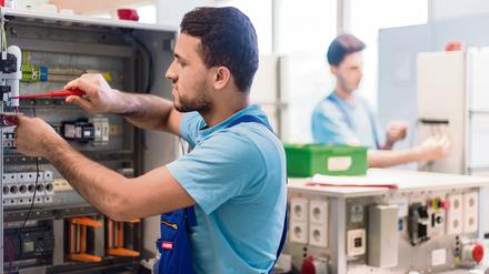 Der 19-jährige Mohammad aus Afghanistan arbeitet im Ausbildungszentrum der Siemens Professional Education an der Verdrahtung eines Schaltschranks. 500.000 qualifizierte Arbeitskräfte aus dem Ausland seien laut der KPMG-Studie pro Jahr nötig, um den Fachkräftemangel in Deutschland auszugleichen.