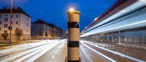 Eine Blitzersäule mit kombinierter Überwachung von Rotlicht und Geschwindigkeit an einer Ampelkreuzung in der Innenstadt.