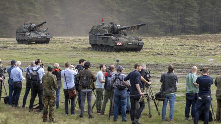  Journalisten beobachten ein Bundeswehrmanöver mit Panzerhaubitzen.
