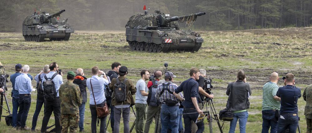  Journalisten beobachten ein Bundeswehrmanöver mit Panzerhaubitzen.