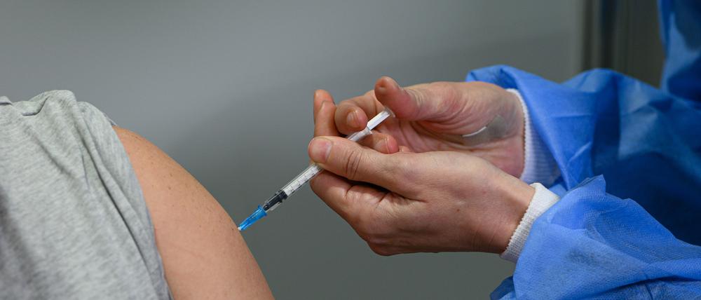 Eine Person lässt sich in einem Impfzentrum gegen Corona immunisieren.