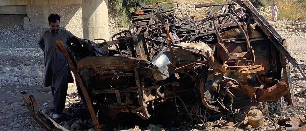 Anwohner und Helfer am Wrack eines ausgebrannten Passagierbusses im Bezirk Lasbela in Pakistan am 29. Januar 2023. 