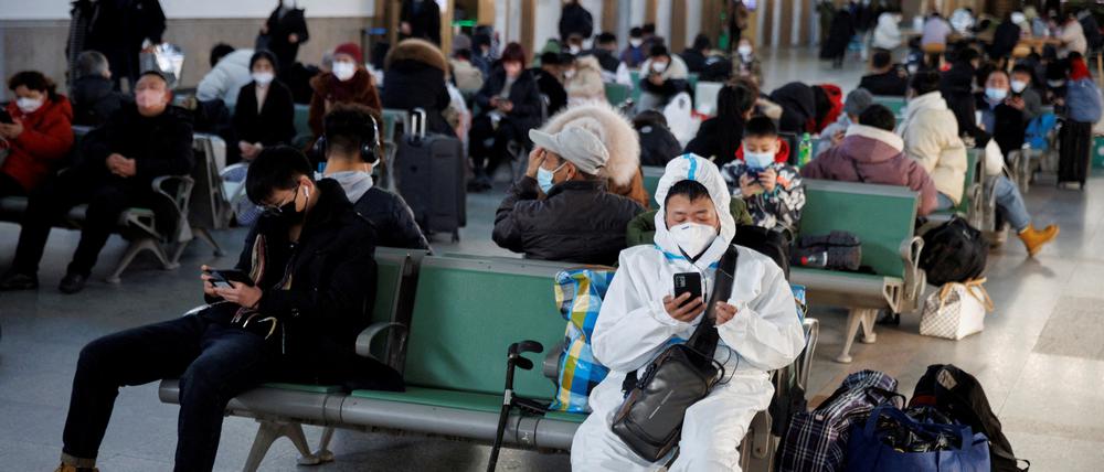 In Peking sitzt eine Person mit einem Schutzanzug.