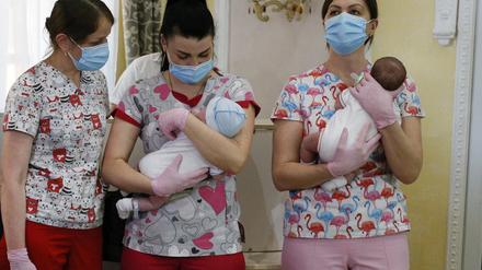 Krankenschwestern in Kiew halten Babys, die von Leihmüttern in der Ukraine geboren wurden, bevor sie ihre Eltern treffen (Archivbild).