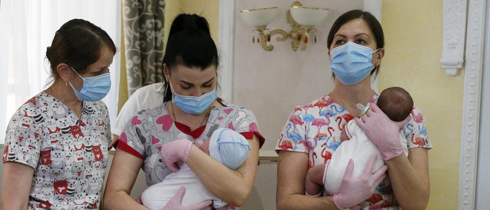Krankenschwestern in Kiew halten Babys, die von Leihmüttern in der Ukraine geboren wurden, bevor sie ihre Eltern treffen (Archivbild).