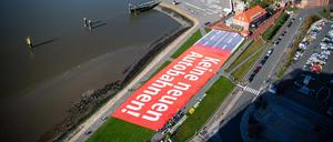 Aktivisten haben auf dem Weserdeich eine Plane mit der Aufschrift ·Keine neuen Autobahnen!· in realer Größe der geplanten Autobahn A20 ausgelegt. Die Klimabewegung Fridays for Future will am Freitag bundesweit gegen den weiteren Ausbau von Autobahnen protestieren.