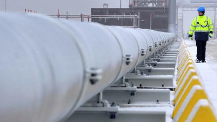 Ein Arbeiter geht an einem Gasrohr vorbei, das die schwimmende Speicher- und Regasifizierungseinheit  „Hoegh Esperanza“ mit dem Festland verbindet.