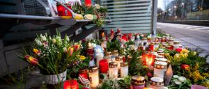 Kerzen und Blumen stehen und liegen im Bahnhof Brokstedt in einem Wartehäuschen.