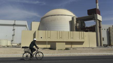 Ein Arbeiter fährt mit seinem Fahrrad vor dem Reaktorgebäude am Atomkraftwerk Buschehr (Archivbild). 