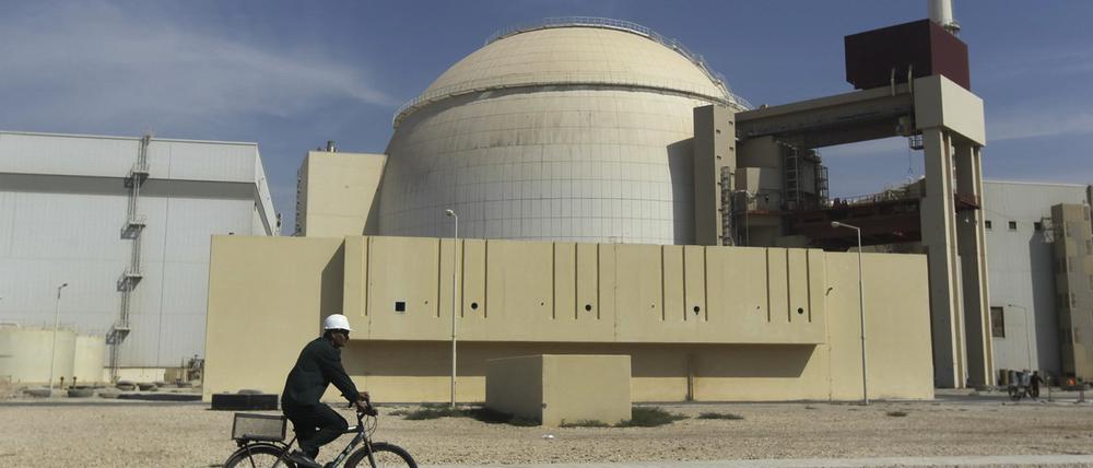 Ein Arbeiter fährt mit seinem Fahrrad vor dem Reaktorgebäude am iranischen Atomkraftwerk Buschehr vorbei (Symbolbild).