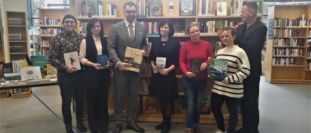 Der Leiter der Stadtbibliothek Pankow Danilo Vetter (links), den Ukrainischer Botschafter in Deutschland Oleksii Makeiev, der Senator für Kultur und Europa von Berlin Dr. Klaus Lederer (rechts) und das Team der Stadtteilbibliothek Karow vor dem ukrainischen Bücherregal am Tag der Buchübergabe.