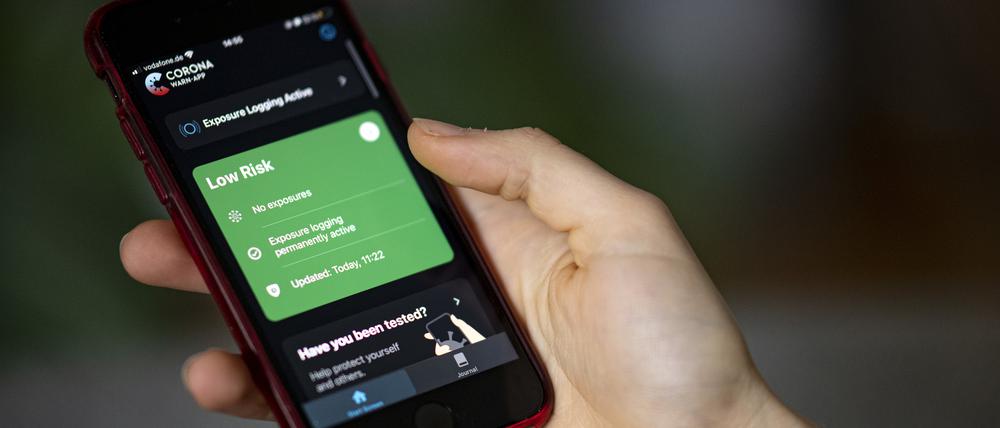Eine Person bedient mit ihrem Smartphone die Corona-Warn App.