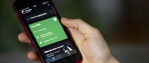Eine Person bedient mit ihrem Smartphone die Corona-Warn App. 