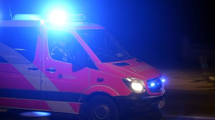 Ein Rettungswagen der Feuerwehr bei einer Einsatzfahrt mit Blaulicht.