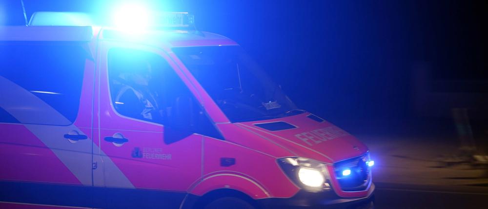 Ein Rettungswagen der Feuerwehr bei einer Einsatzfahrt mit Blaulicht.
