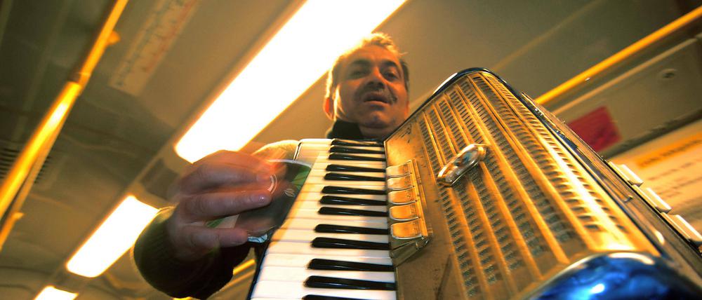 Mann mit Akkordeon macht Musik in der U-Bahn.